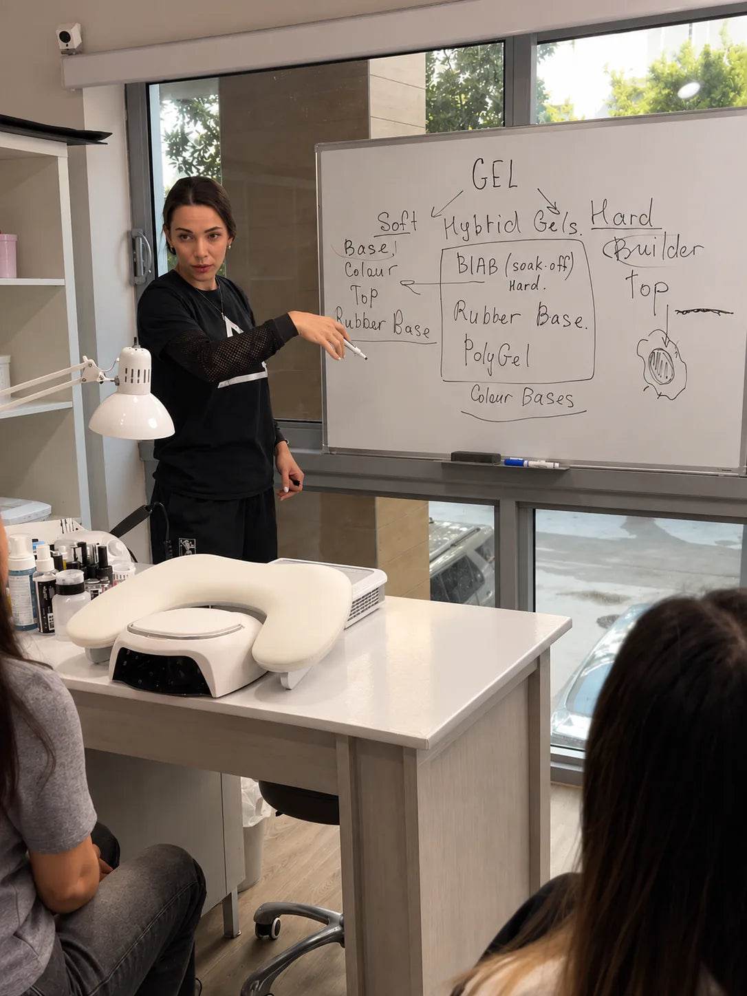 Siranush Ambartsumian teaches students beside a whiteboard during a Nailspiracy Upgrade class on professional gel systems.